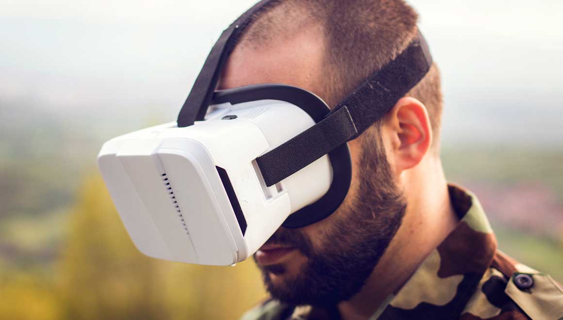 A man in combat fatigues wearing VR goggles.