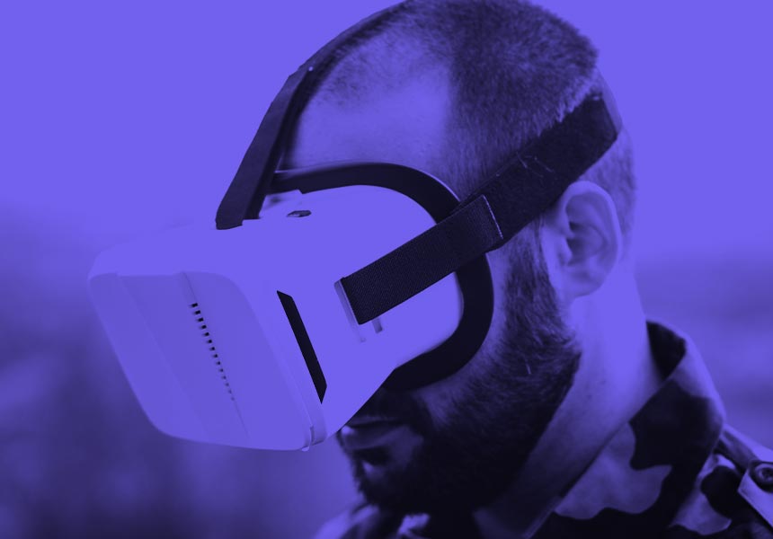 A man in combat fatigues wearing VR goggles.